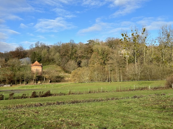 Dans la vallée, nous devinons le château de Fontaine-Châtel, avec, au premier plan, son colombier.