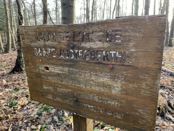 Cette veille pancarte indique l'emplacement de la croix de pierre qui succédait à une chapelle érigée sur le lieu de la mort de l'âne de Sainte-Austreberthe. L'âne fut tué par un loup qui fut condamné à le remplacer.