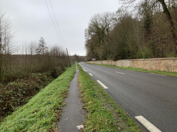Pour rejoindre Fontaine-l'Abbé, nous devons suivre la D133 sur 400 mètres le long du mur du château de Courcelles. Comme on le voit, un sentier piétonnier a été aménagé sur l'accotement.